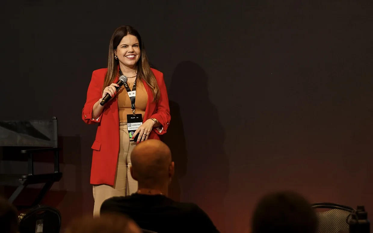 Luana Dias palestrando no palco para plateia